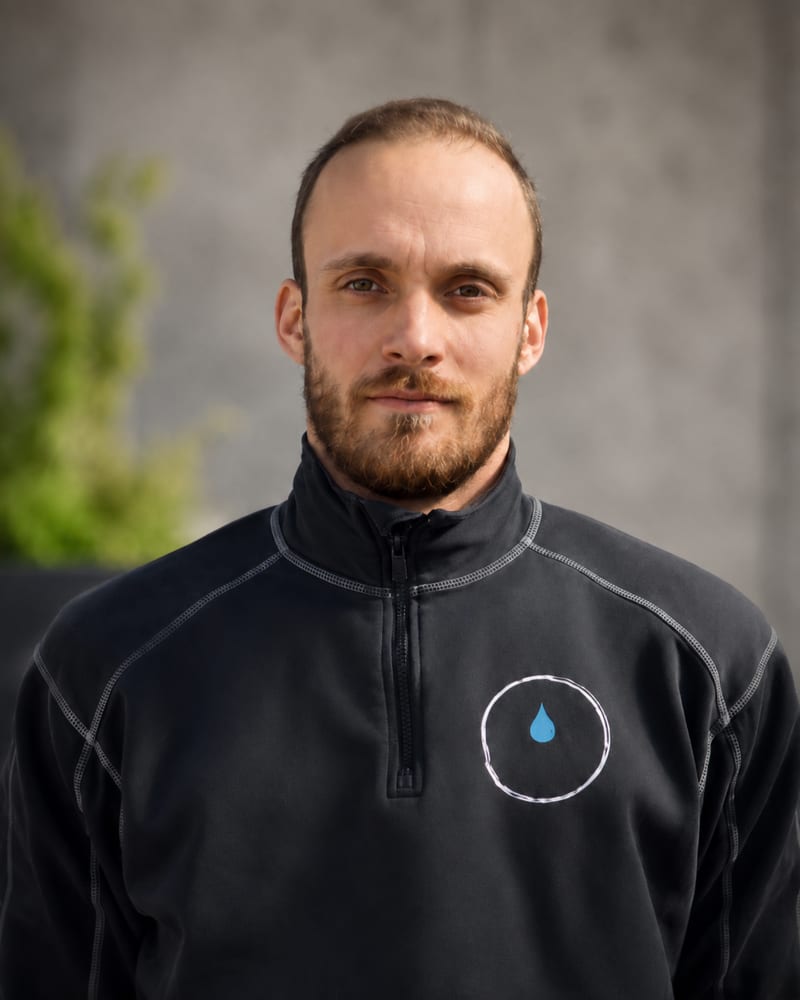 Porträt von Fabian Wagner in Arbeitskleidung mit Firmenlogo
